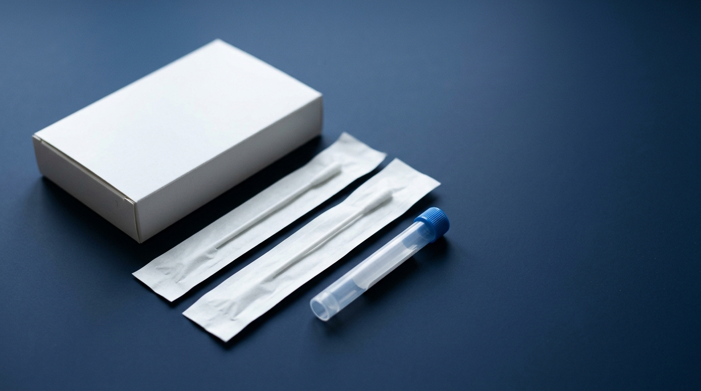 Ein DNA-Testkit mit zwei verpackten Wattestäbchen und einem Probenröhrchen auf dunkelblauem Untergrund